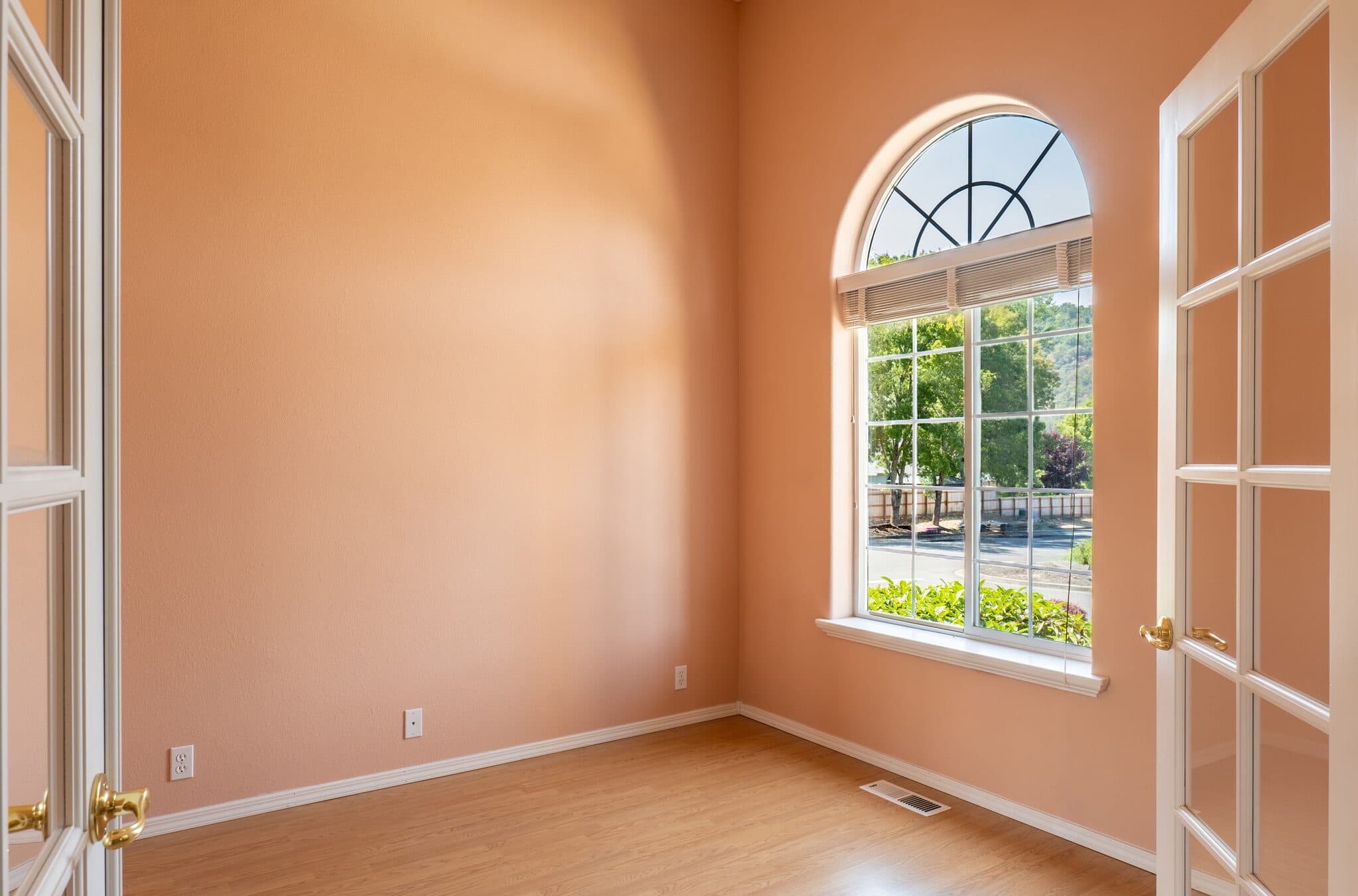 Bedroom with arched window and French doors — real estate photography by Hahn Media, Oregon