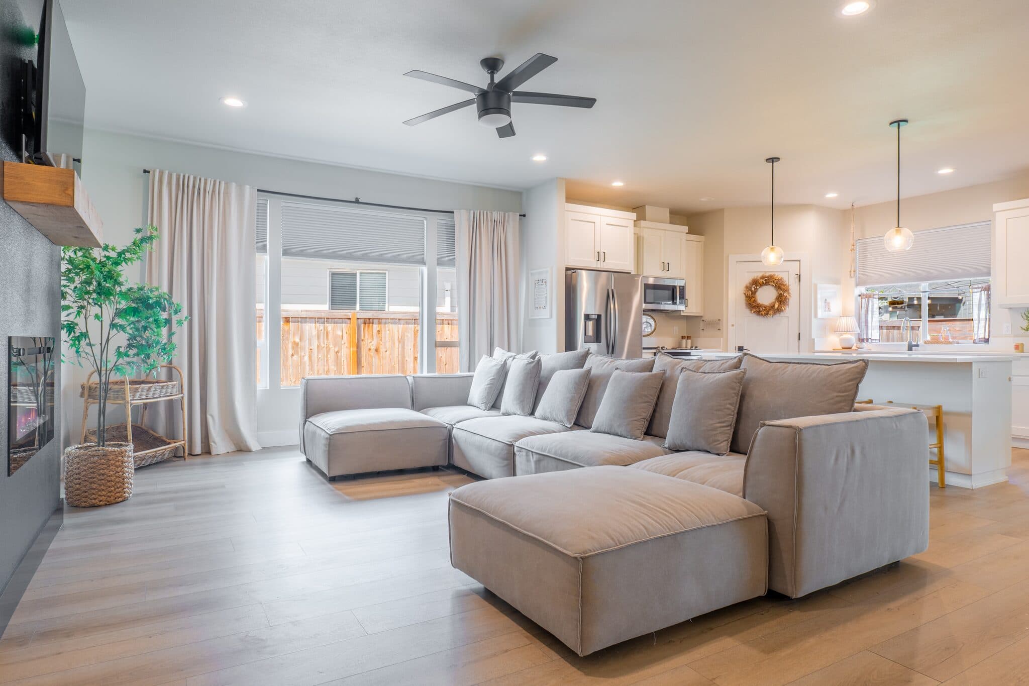 Open-concept living room with sectional sofa and kitchen — real estate photography by Hahn Media, Oregon