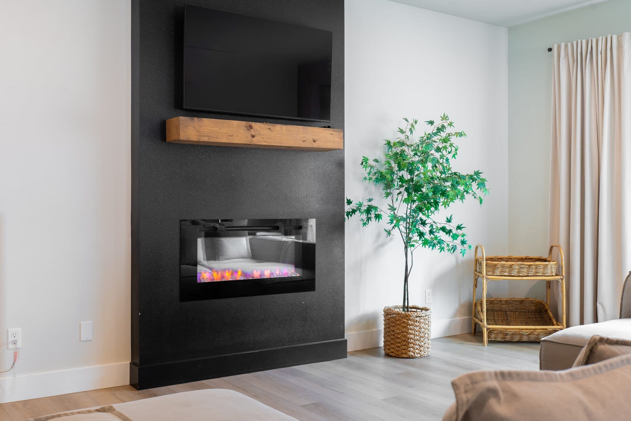 Living room with black fireplace wall — real estate photography by Hahn Media, Oregon